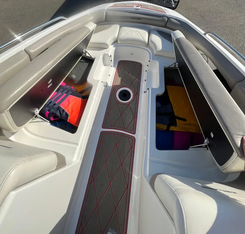Slide: The Image of 2011 Sea-Doo 230 Wake boat interior with open storage compartments and seating. - 13