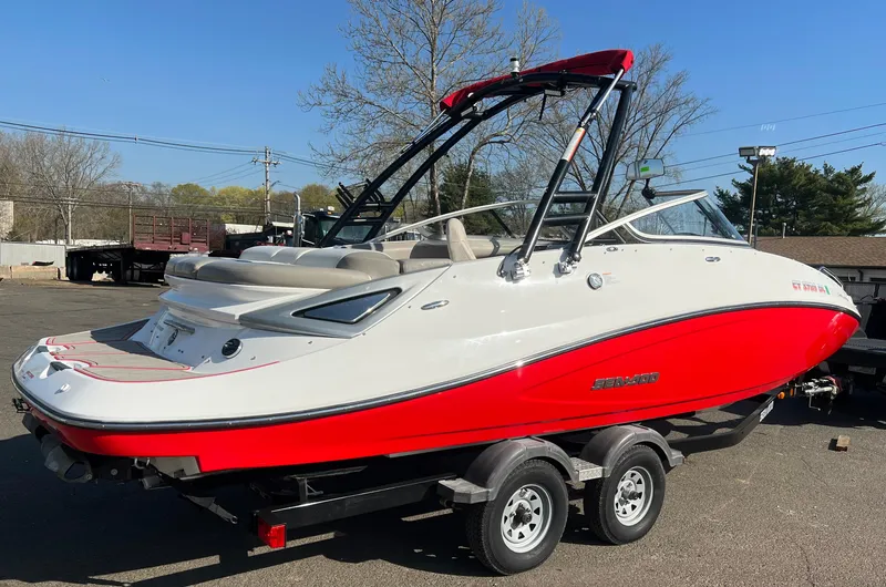 Slide: The Image of 2011 Sea-Doo 230 Wake (510 hp) boat on a trailer, red and white exterior. - 3