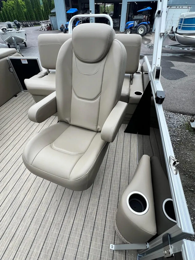 Slide: The Image of 2024 Sylvan 8522 CLZ DH Mirage boat interior with beige captain's chair and cup holders. - 30
