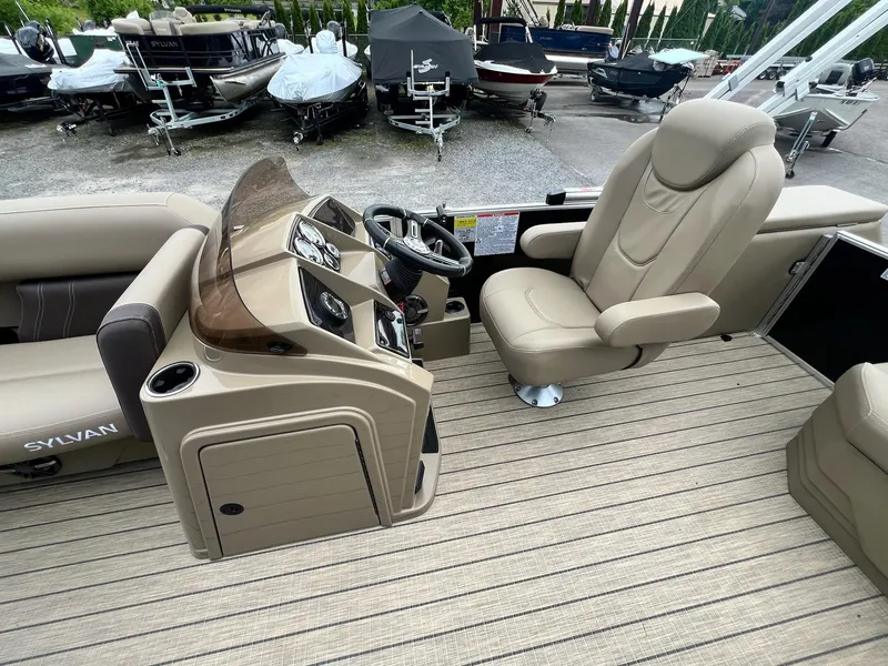 Slide: The Image of 2024 Sylvan 8522 CLZ DH Mirage boat interior with captain's chair and control console. - 5