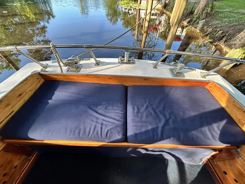 Slide: The Image of 1930 Classic ACF 47' Motor Yacht with cushioned seating by the water. - 8
