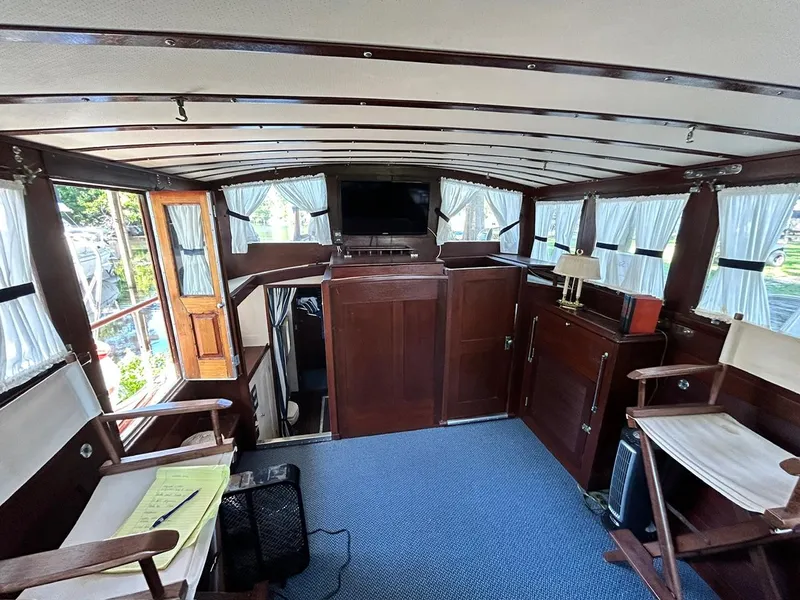 Slide: The Image of Interior of a 1930 Classic ACF 47' Motor Yacht with wooden furnishings and blue carpet. - 47