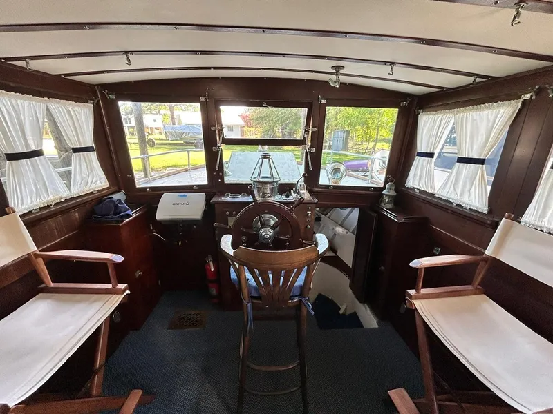 Slide: The Image of Interior of 1930 Classic ACF 47' Motor Yacht helm with wooden accents and white curtains. - 35