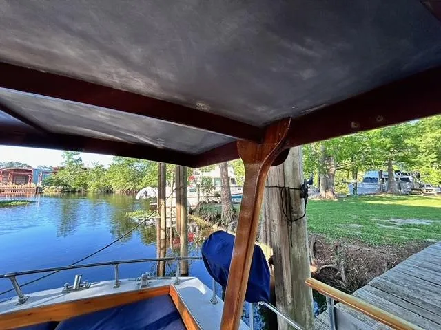 Slide: The Image of View from the deck of a 1930 Classic ACF 47' Motor Yacht docked by a serene riverside. - 17