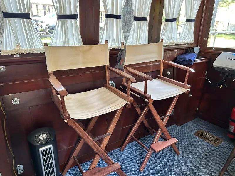 Slide: The Image of Interior of 1930 Classic ACF 47' Motor Yacht with wooden chairs and curtains. - 49