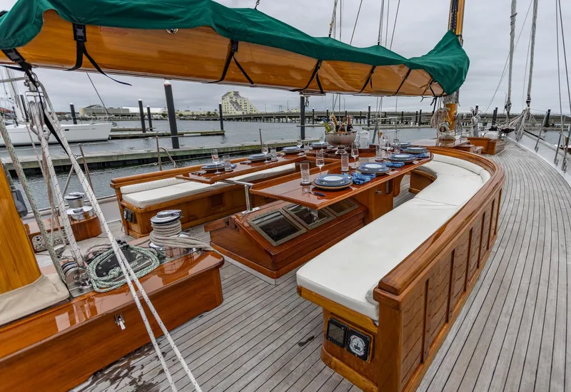 Slide: The Image of 1929 Lyman-Morse Staysail Schooner with elegant wooden deck and dining area. - 15