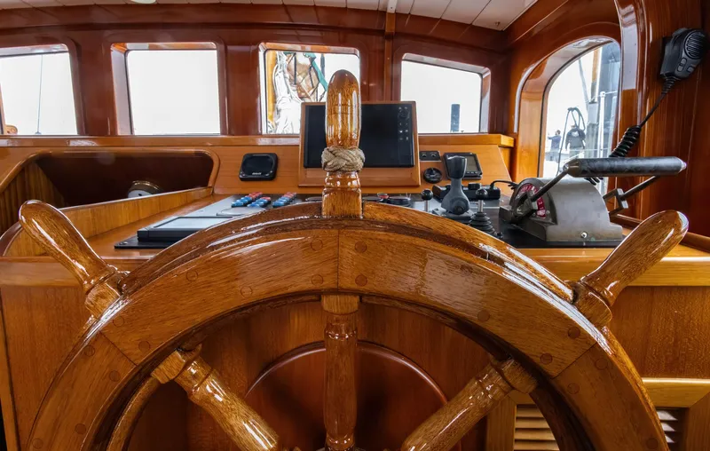Slide: The Image of 1929 Lyman-Morse Staysail Schooner helm with wooden wheel and navigation instruments. - 23