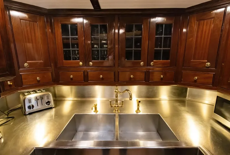 Slide: The Image of Luxurious wooden kitchen cabinets with stainless steel countertops and double sink on a 1929 Lyman-Morse Staysail Schooner. - 36