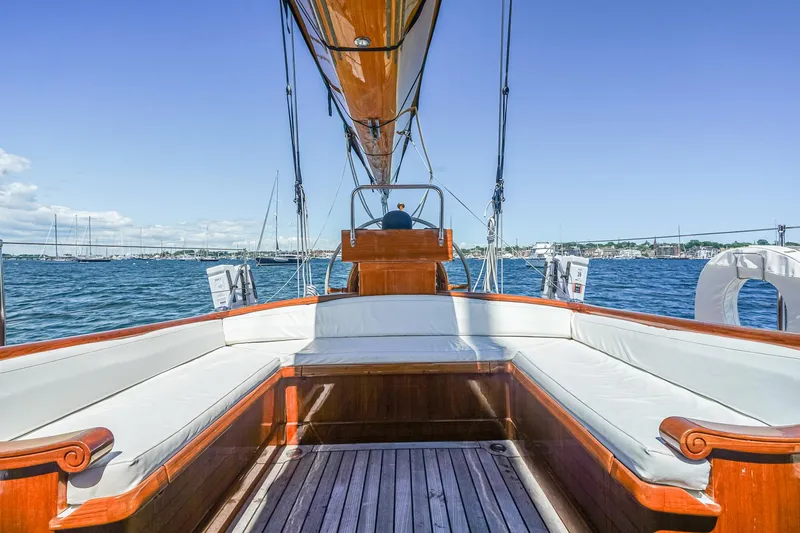 Slide: The Image of 1929 Lyman-Morse Staysail Schooner with wooden deck and white seating on calm waters. - 6