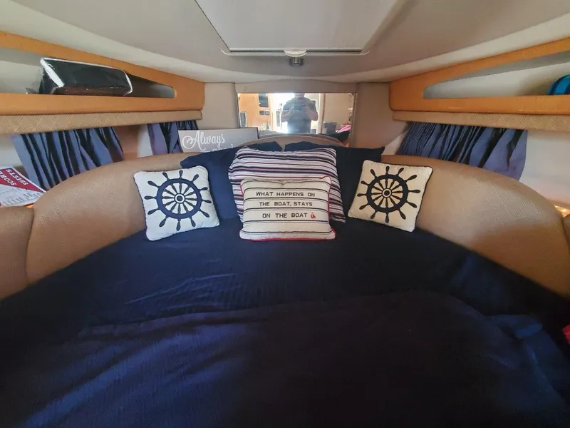 Slide: The Image of Interior cabin of a 2006 Chaparral 290 Signature boat with nautical-themed pillows. - 2