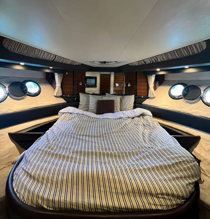 Slide: The Image of Luxurious bedroom in a 2011 Marquis 500 Sport Coupe yacht with striped bedding. - 6