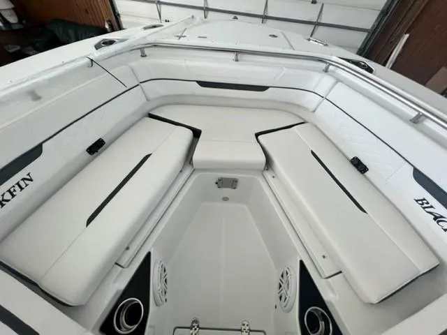 Slide: The Image of 2024 Blackfin 252 DC boat interior with white cushioned seating and stainless steel fixtures. - 7