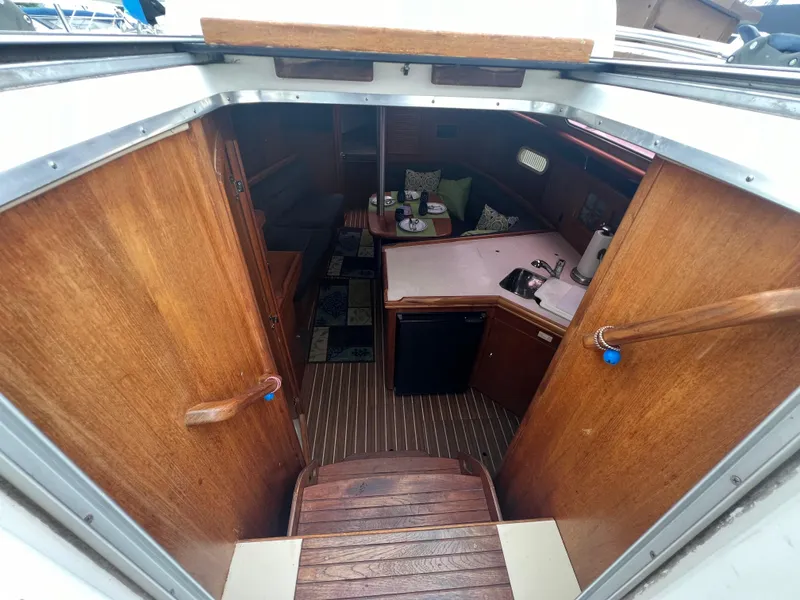 Slide: The Image of Interior view of 2005 Hunter 36 sailboat, featuring wooden cabinetry and compact kitchen. - 26