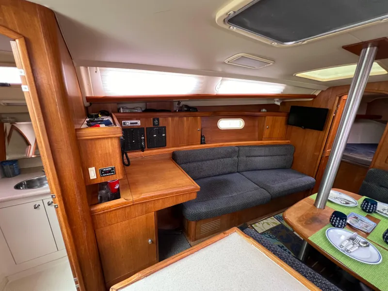 Slide: The Image of Interior of a 2005 Hunter 36 sailboat with wooden cabinetry and seating area. - 32