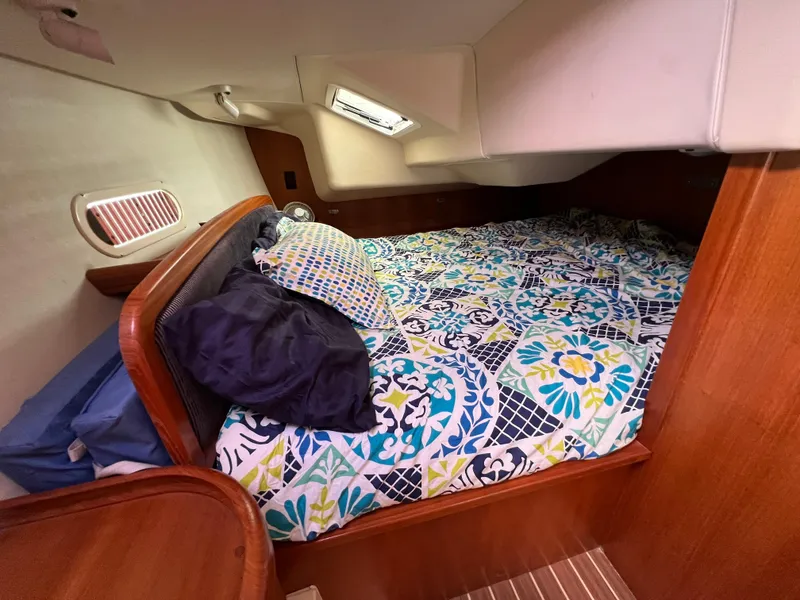 Slide: The Image of Cozy cabin bed in a 2005 Hunter 36 sailboat with colorful bedding. - 49