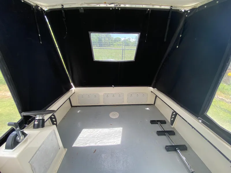 Slide: The Image of Interior of 2005 C-Hawk Pilothouse 25 boat, featuring spacious cabin with window and controls. - 17