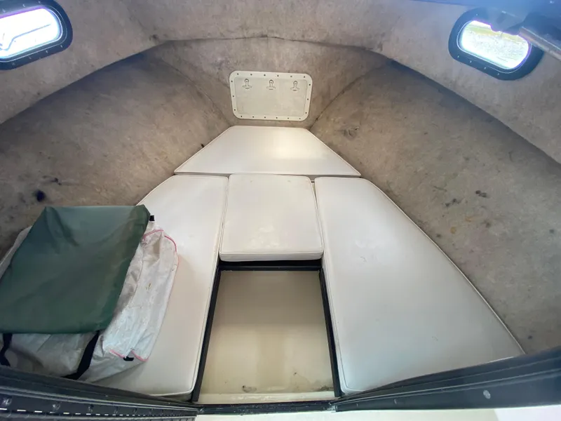 Slide: The Image of 2005 C-Hawk Pilothouse 25 interior cabin with cushioned seating and small windows. - 19
