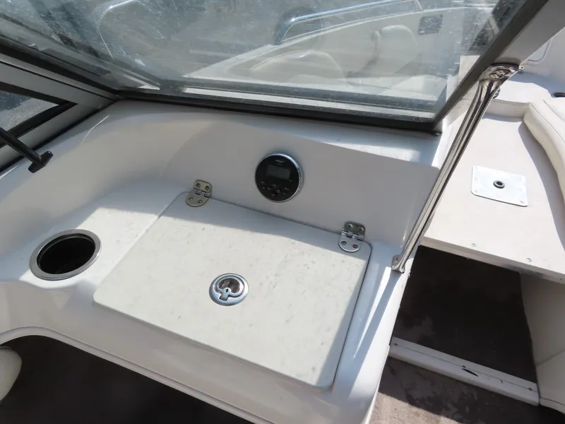 Slide: The Image of 2013 Stingray 195LX boat interior with storage compartment and cup holder. - 14