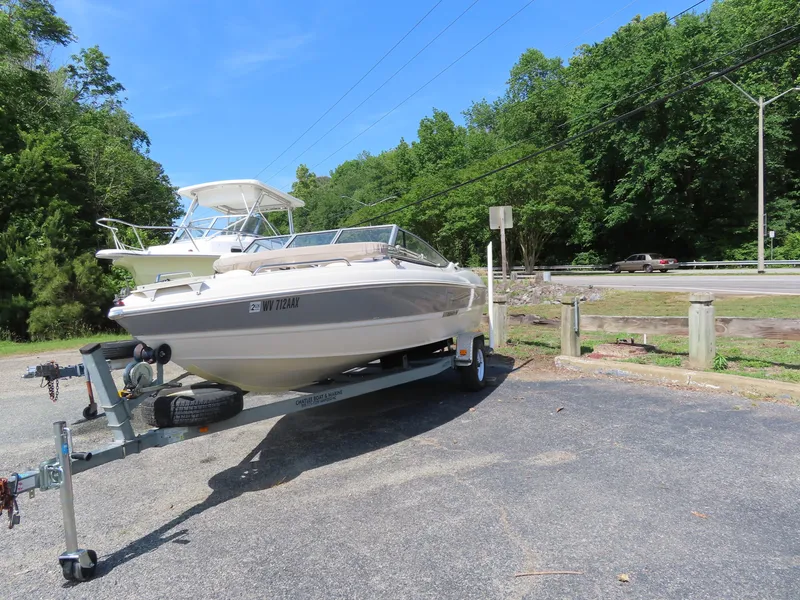 Slide: The Image of 2013 Stingray 195LX boat on a trailer in a parking lot. - 2