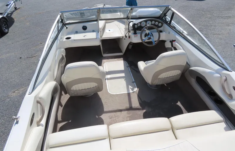 Slide: The Image of 2013 Stingray 195LX boat interior with beige seating and steering console. - 7