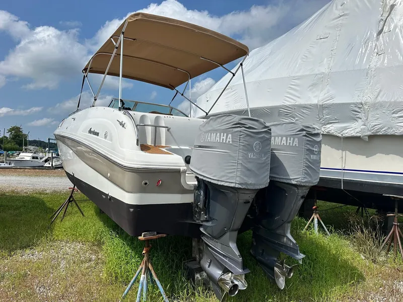 Slide: The Image of 2003 Hurricane 26 SD boat with Yamaha engines, parked on grass under a blue sky. - 1