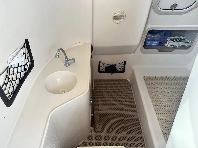Slide: The Image of 2003 Hurricane 26 SD boat interior with sink and storage compartments. - 10