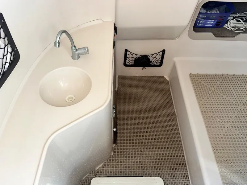 Slide: The Image of 2003 Hurricane 26 SD boat interior with sink and storage compartments. - 12
