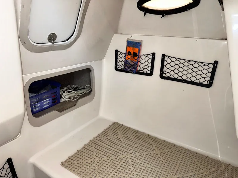 Slide: The Image of Interior of 2003 Hurricane 26 SD boat with storage compartments and netting. - 14