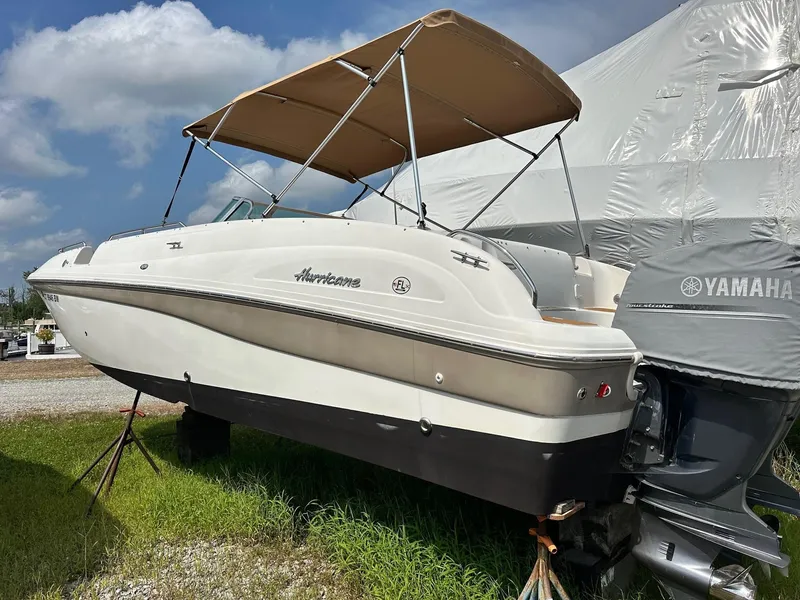 Slide: The Image of 2003 Hurricane 26 SD boat with Yamaha engine, parked on grass under a blue sky. - 2