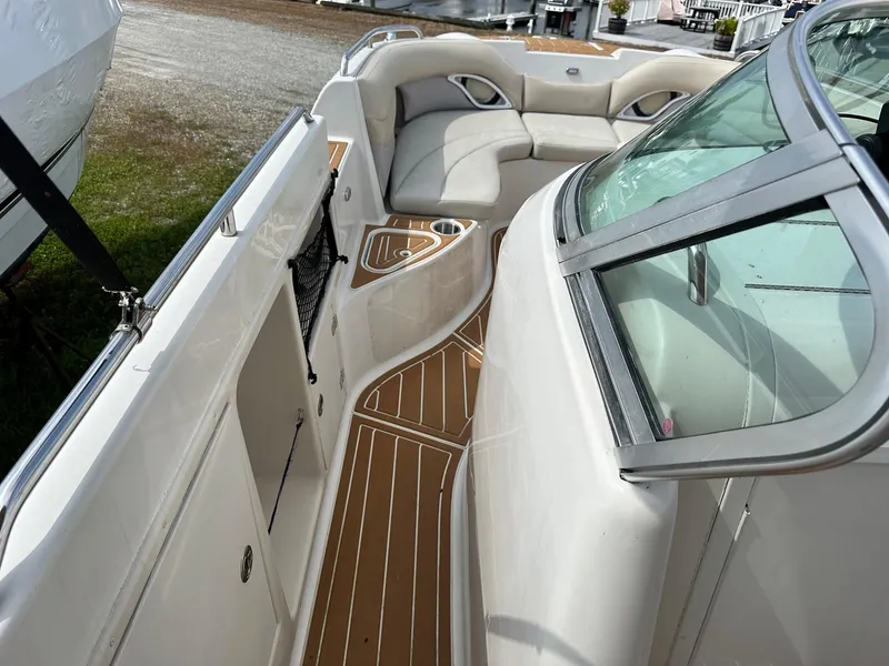 Slide: The Image of 2003 Hurricane 26 SD boat interior with cushioned seating and wood-patterned flooring. - 23