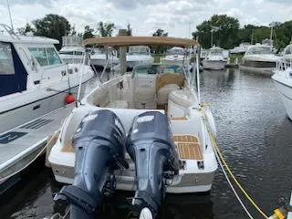 Slide: The Image of 2003 Hurricane 26 SD boat docked with twin outboard motors. - 25