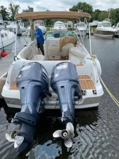 Slide: The Image of 2003 Hurricane 26 SD boat with twin outboard motors docked at a marina. - 26