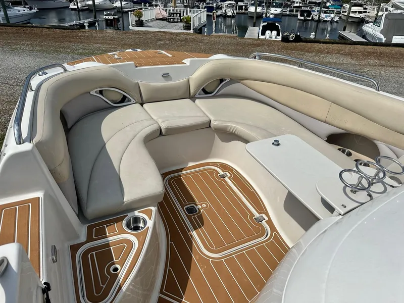 Slide: The Image of 2003 Hurricane 26 SD boat interior with cushioned seating and cup holders at marina. - 29
