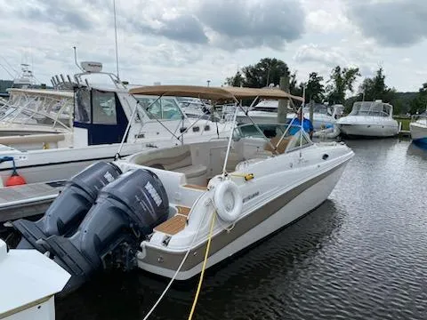 Slide: The Image of 2003 Hurricane 26 SD boat docked at a marina with twin outboard motors. - 31