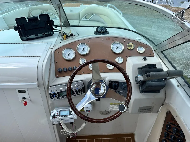 Slide: The Image of 2003 Hurricane 26 SD boat dashboard with steering wheel and control panel. - 37