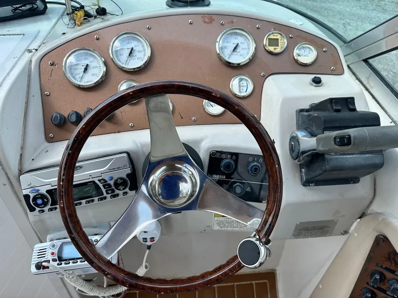 Slide: The Image of 2003 Hurricane 26 SD boat dashboard with steering wheel and gauges. - 38