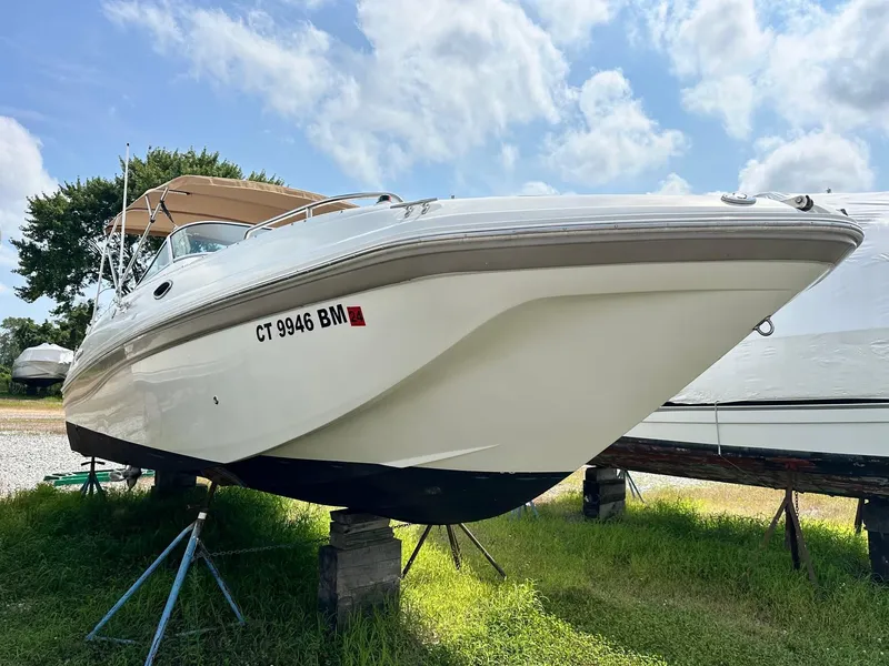 Slide: The Image of 2003 Hurricane 26 SD boat on stands, grassy area, clear sky background. - 5