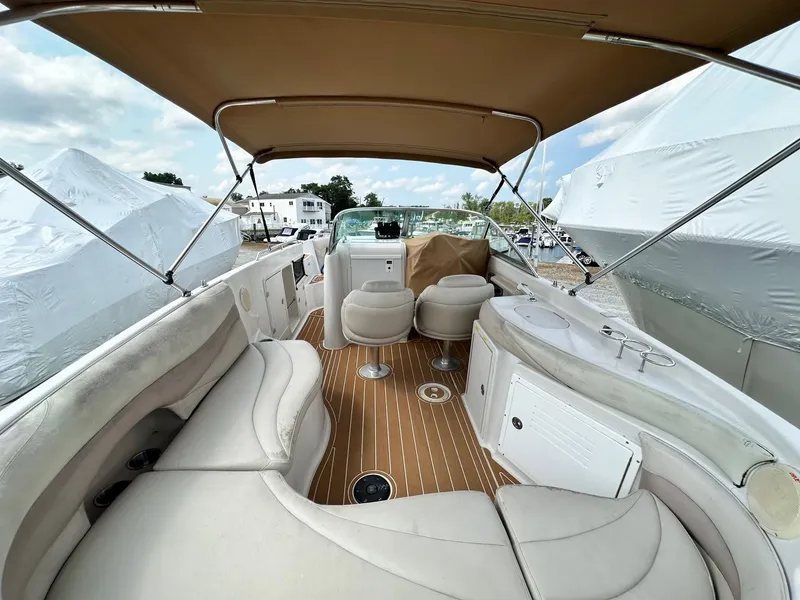 Slide: The Image of 2003 Hurricane 26 SD boat interior with seating and canopy, docked outdoors. - 8