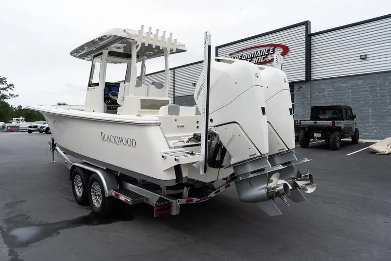 Slide: The Image of 2025 Blackwood 290 OPEN boat on a trailer, rear view with dual outboard engines. - 10