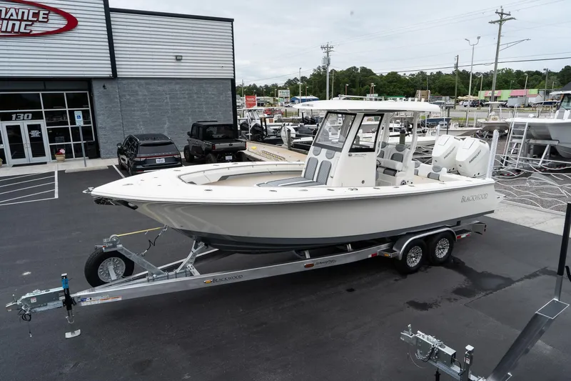 Slide: The Image of 2025 Blackwood 290 OPEN boat on a trailer outside a dealership. - 2