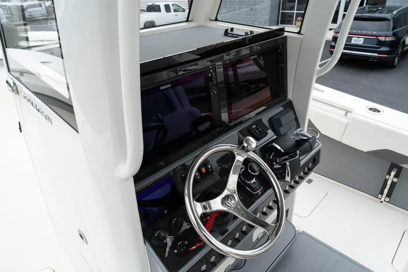 Slide: The Image of 2025 Blackwood 290 OPEN boat dashboard with steering wheel and dual display screens. - 40
