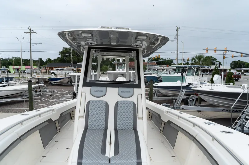 Slide: The Image of 2025 Blackwood 290 OPEN boat with sleek design and spacious seating at a marina. - 43