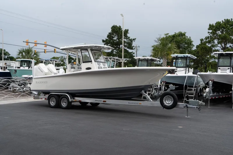 Slide: The Image of 2025 Blackwood 290 OPEN boat on a trailer in a dealership lot. - 6