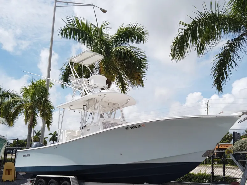 The Image of 2005 Regulator 32 Forward Seating boat on trailer, surrounded by palm trees. - 0