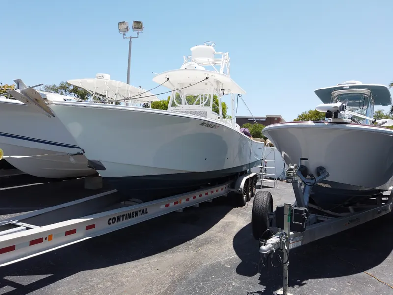 Slide: The Image of 2005 Regulator 32 Forward Seating boat on a Continental trailer in a parking lot. - 21