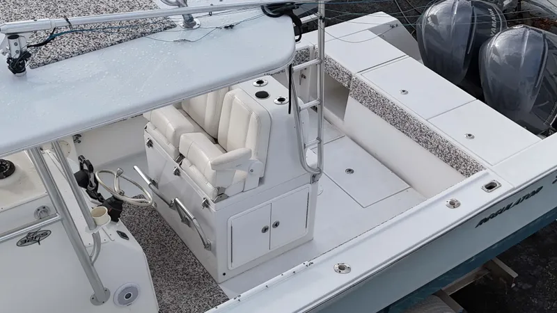 Slide: The Image of 2005 Regulator 32 Forward Seating boat interior with dual engines and white seating. - 24