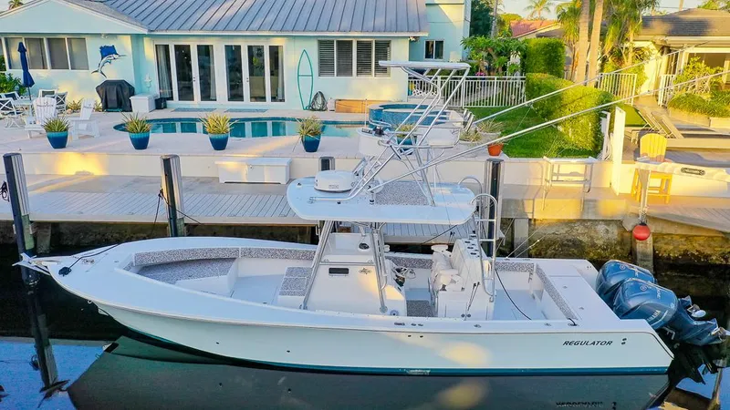 Slide: The Image of 2005 Regulator 32 Forward Seating boat docked by a waterfront home. - 6