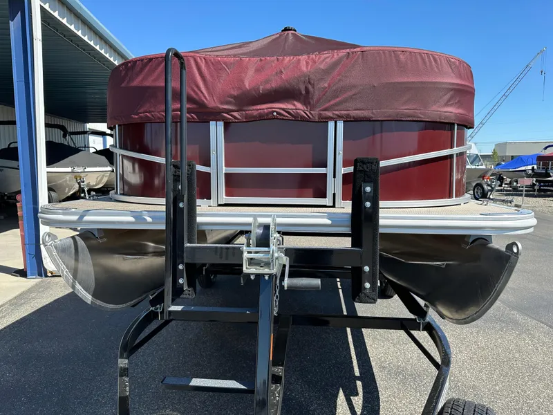 Slide: The Image of 2024 SunChaser Vista 18 LR pontoon boat on a trailer, front view. - 2