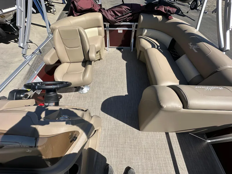 Slide: The Image of 2024 SunChaser Vista 18 LR pontoon boat interior with beige seating and carpet. - 5