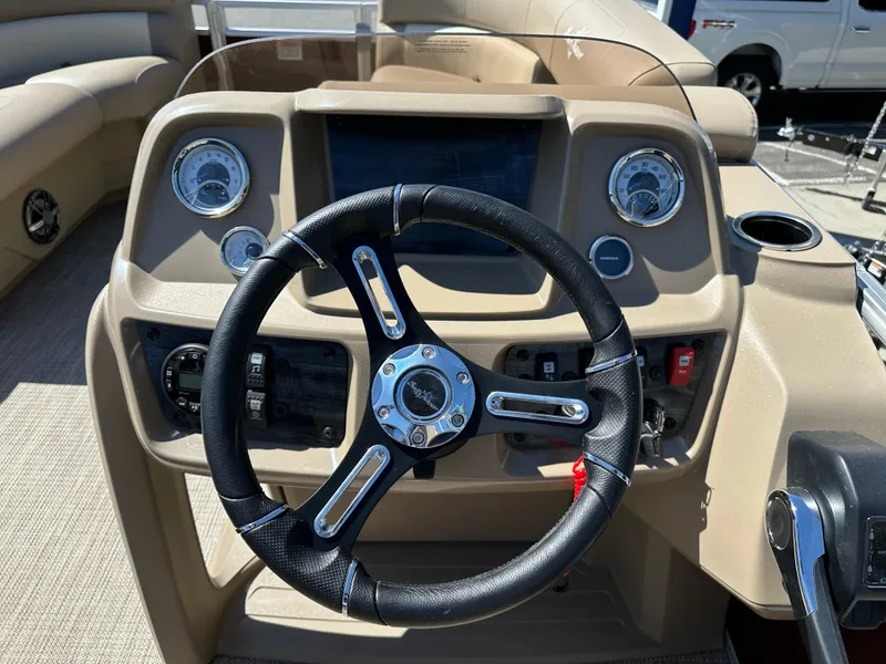 Slide: The Image of 2024 SunChaser Vista 18 LR boat dashboard with steering wheel and control panel. - 8